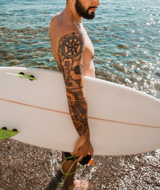 Free Photo crop man with surfboard near clean sea