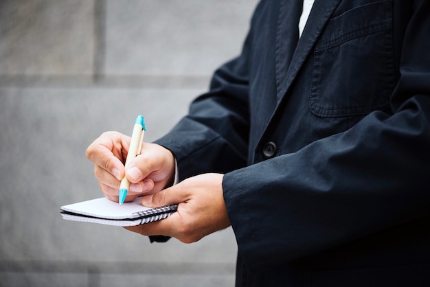 Crop man writing in notebook