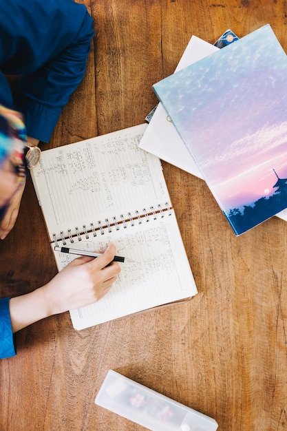 Crop person fulfilling exercise in classroom