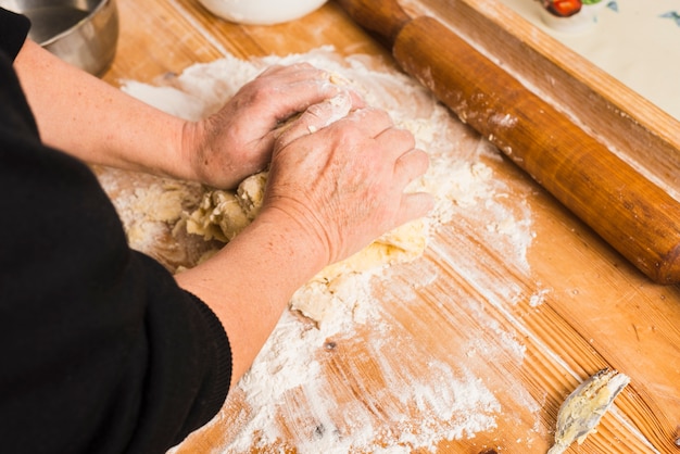 Free photo crop person kneading dough