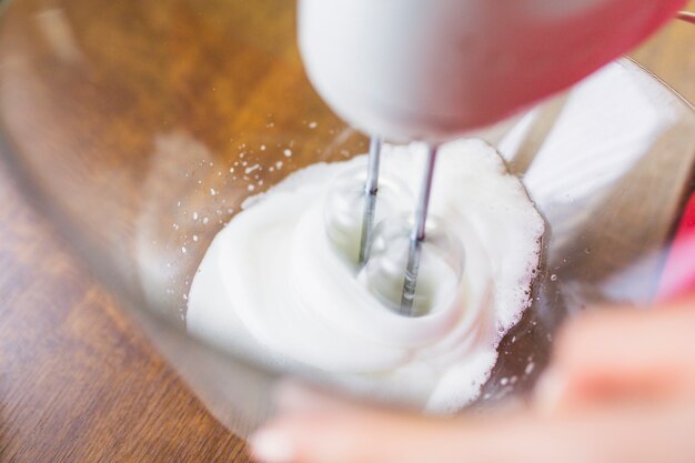 Crop person mixing ingredients with mixer