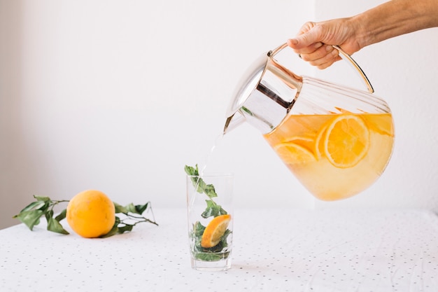 Free photo crop person pouring lemonade