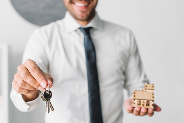 Free photo crop real estate agent with keys and house