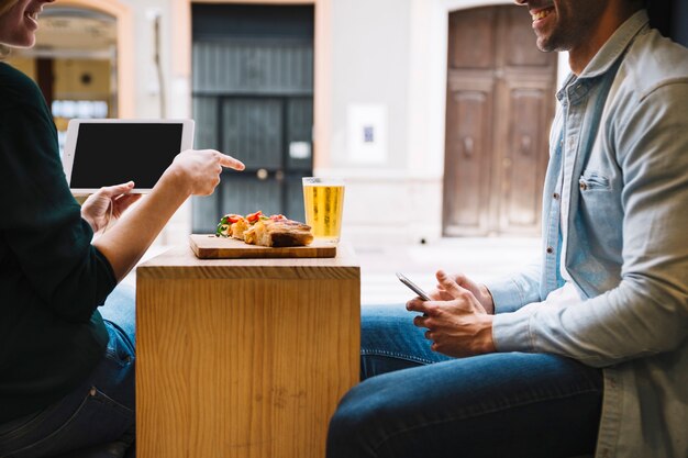 Crop smiling couple talking in cafe