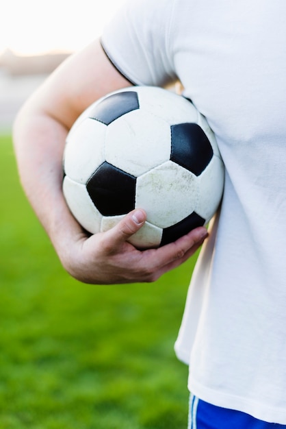 Crop sportsman holding ball