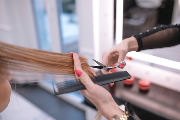 Free photo crop stylist trimming hair ends in salon