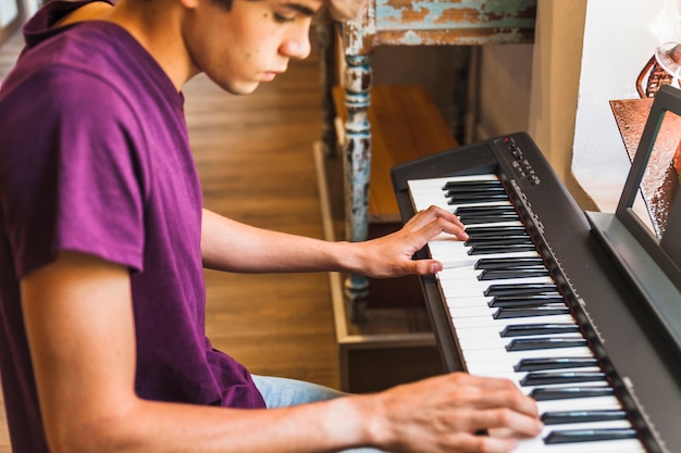 Free photo crop teenager playing piano