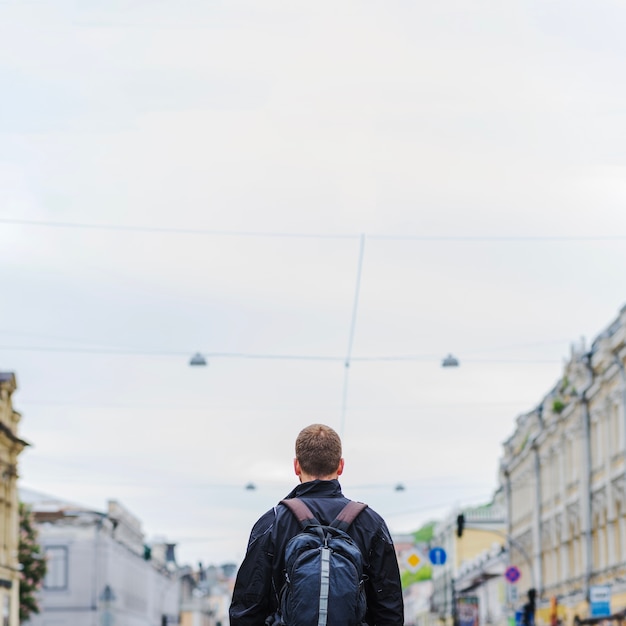 Crop unrecognizable backpacker on street