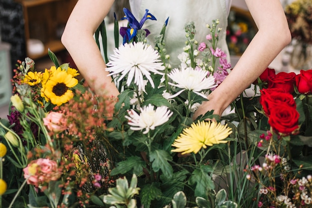 Crop woman arranging flowers