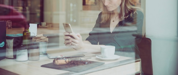 Crop woman browsing smartphone in nice cafe