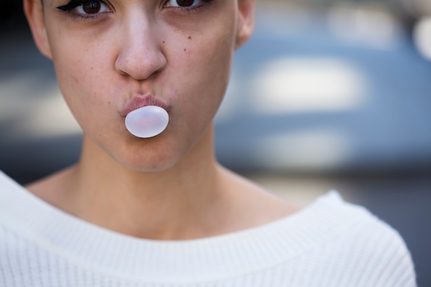 Free photo crop woman chewing gum and looking at camera