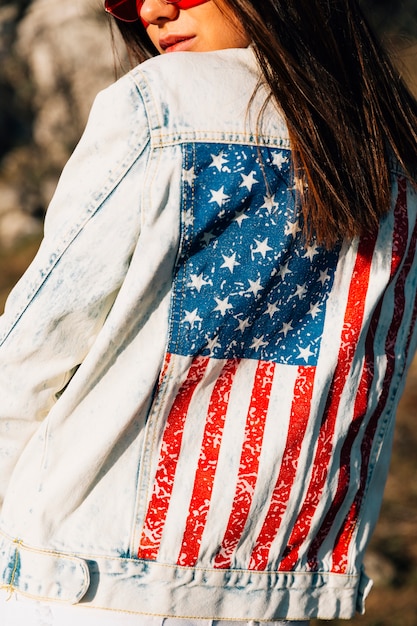 Crop woman in denim jacket with American flag 