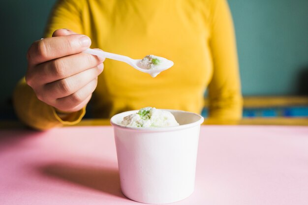 Crop woman eating ice-cream