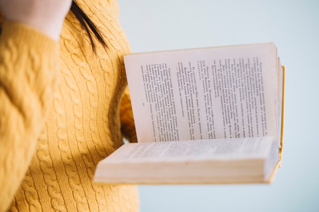 Crop woman enjoying reading