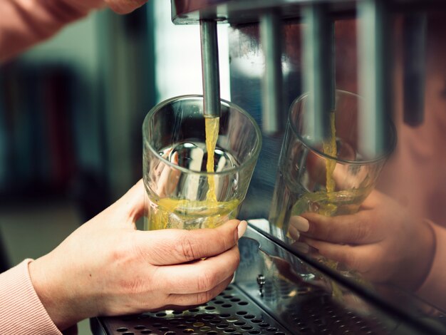 Crop woman hand pouring beverage in glass