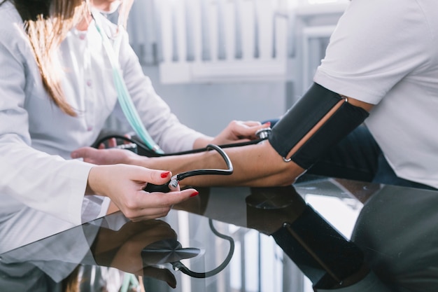 Free photo crop woman measuring pulse to patient