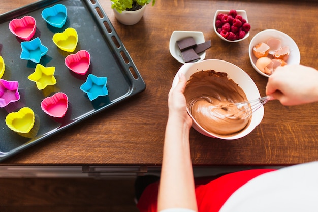 Free photo crop woman mixing batter for cupcakes