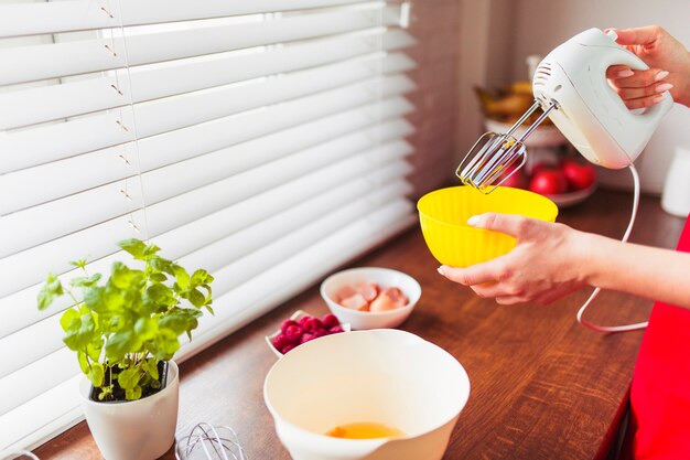 Crop woman mixing ingredients