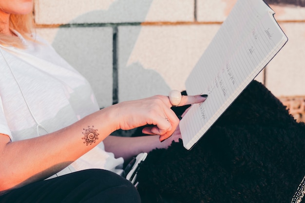 Free Photo crop woman pointing at book studying