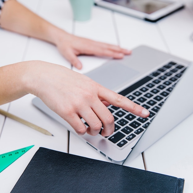 Crop woman pointing at screen of laptop