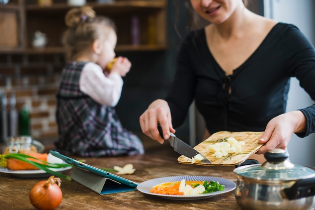 Free Photo crop woman putting cut apple on plate