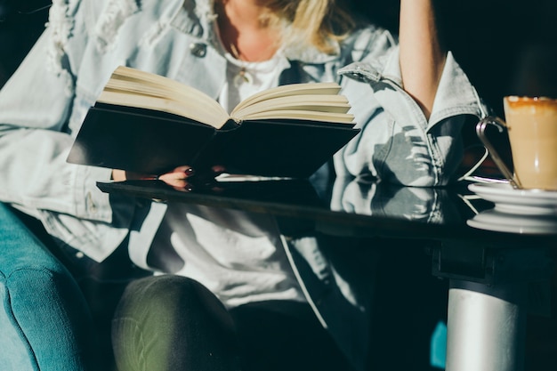 Free photo crop woman reading in cafe