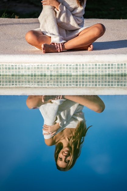 Free photo crop woman resting near pool