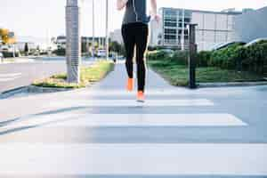 Free photo crop woman running on crosswalk