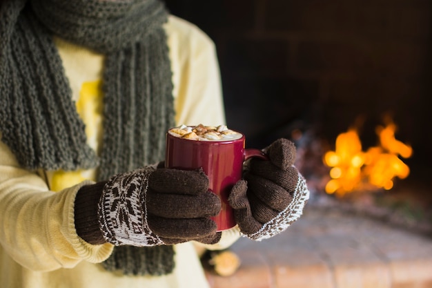 Crop woman showing mug of hot chocolate