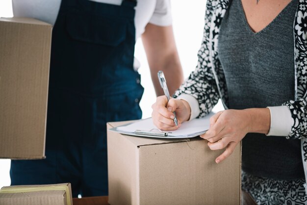 Free photo crop woman signing on carton box