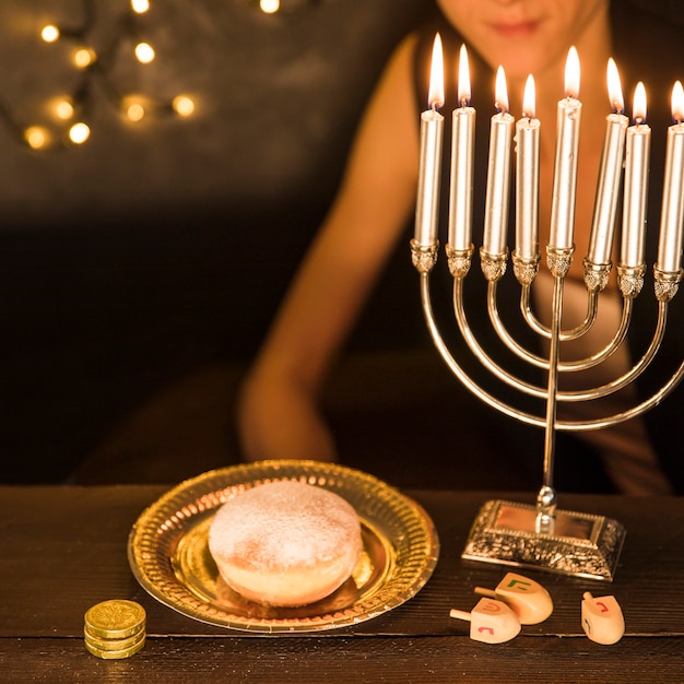 Free Photo crop woman sitting near hanukkah symbols