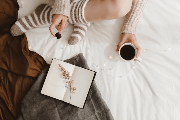 Free photo crop woman snacking near opened book