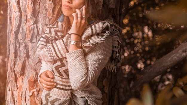 Free Photo crop woman speaking on smartphone near tree