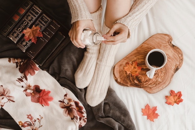 Free photo crop woman taking sugar for tea on bed