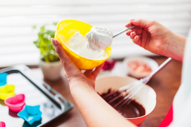 Crop woman taking whipped cream for pastry