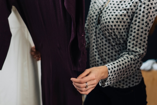 Free photo crop woman touching dress in shop