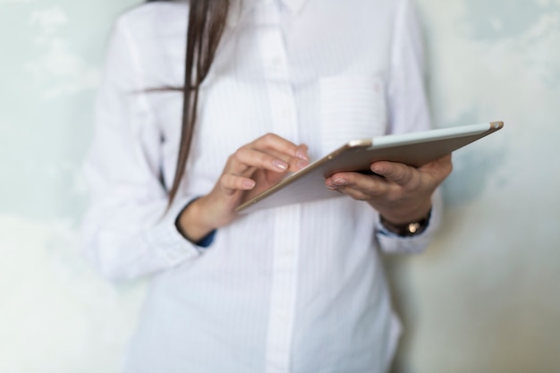 Crop woman in white using tablet