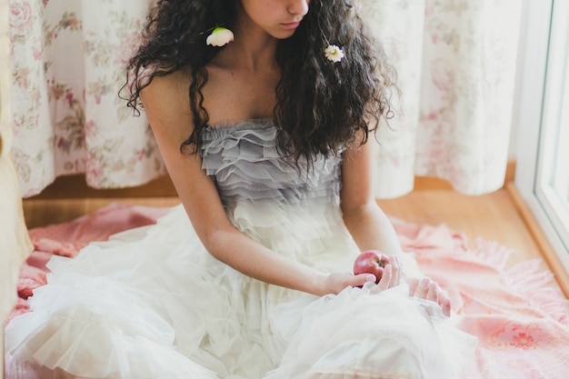 Crop woman with flowers and apple