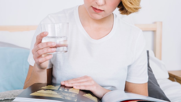 Free photo crop woman with glass reading magazine