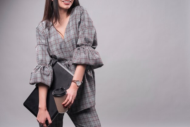 Crop woman with laptop and cup