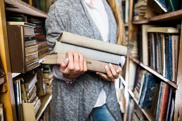 Free photo crop woman with pile of books