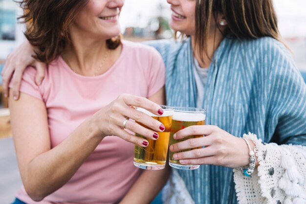 Crop women clinking glasses