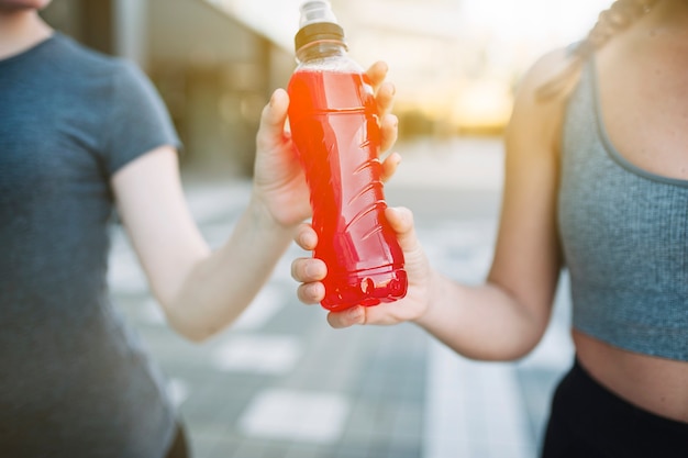 Free photo crop women with red drink in bottle