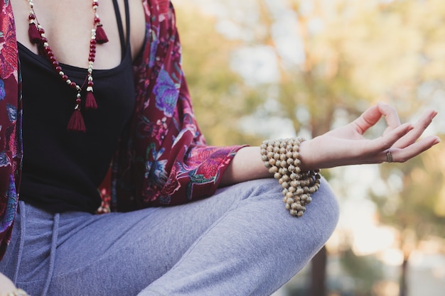 Free Photo crop young woman meditating in park