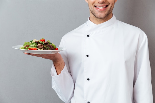 Free photo cropped image of a smiling male chef dressed in uniform