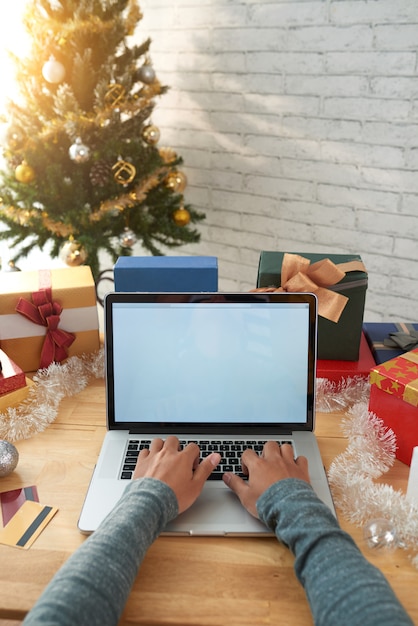 Free photo cropped man making online purchases on laptop before christmas