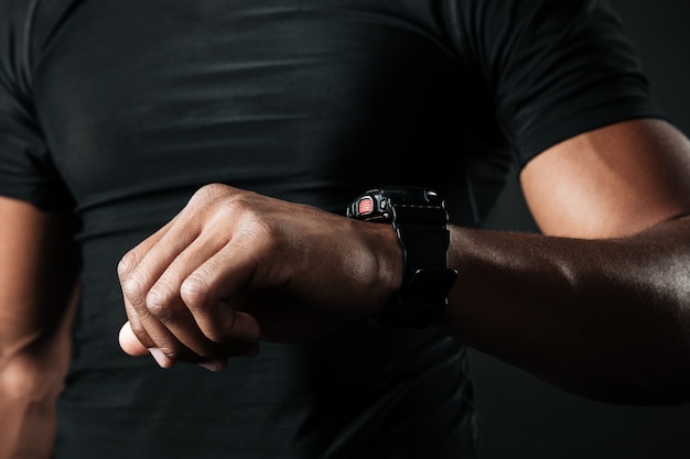 Cropped photo of afro american muscular man checking time