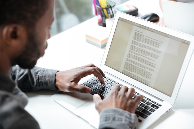 Free photo cropped photo of serious young man sitting in office coworking