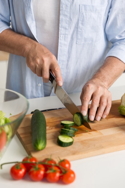 Cropped picture of mature attractive man cooking salad.