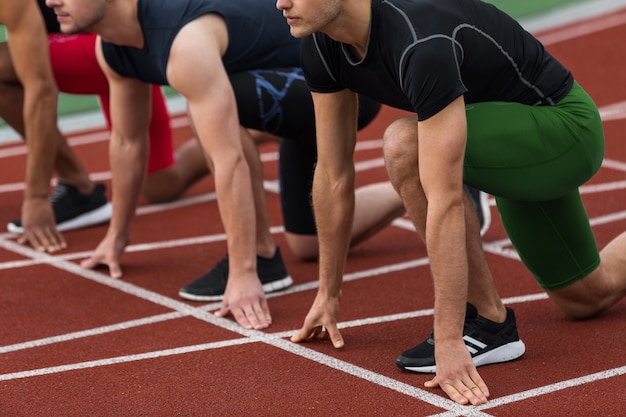 Free photo cropped picture of multiethnic athlete group ready to run